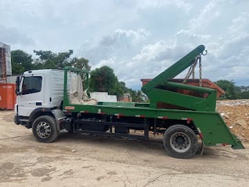 Caminhão da Norte Entulho com caçamba verde na obra